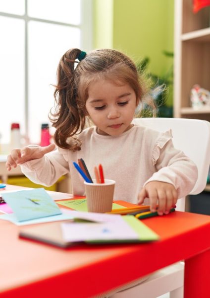 adorable-hispanic-girl-student-sitting-table-drawing-paper-kindergarten_839833-7686