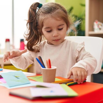 adorable-hispanic-girl-student-sitting-table-drawing-paper-kindergarten_839833-7686